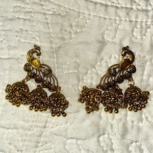 Gold peacock dangle earrings.